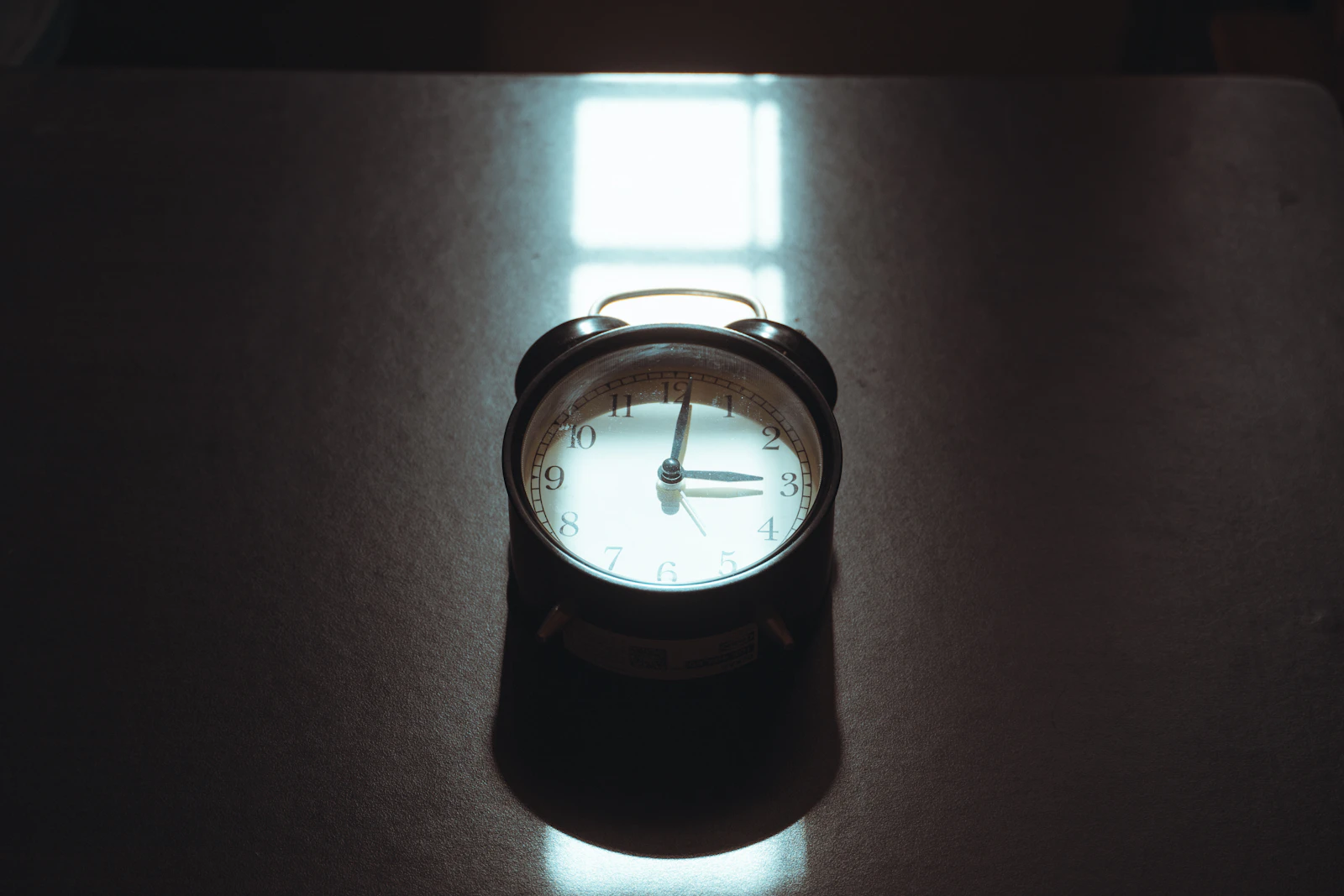 An alarm clock lit in a dark room
