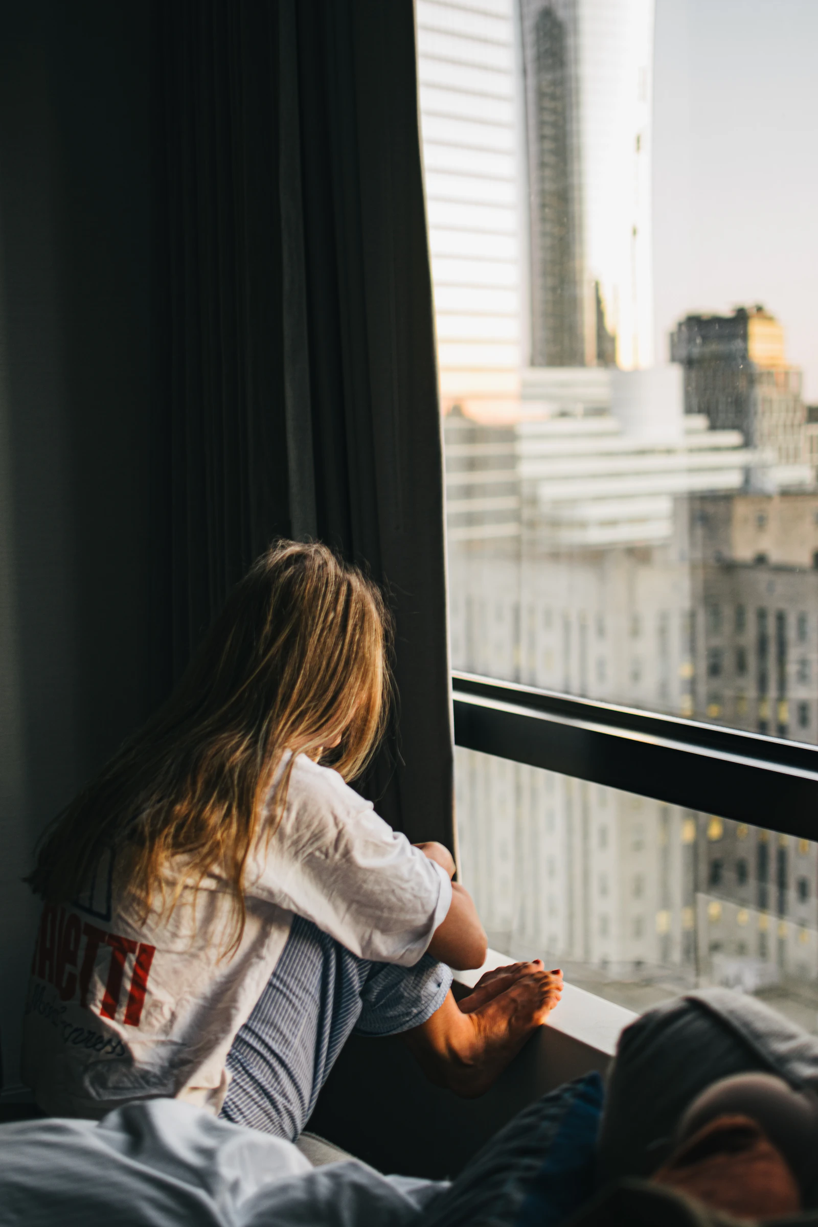 A woman sitting by a bright window in the morning